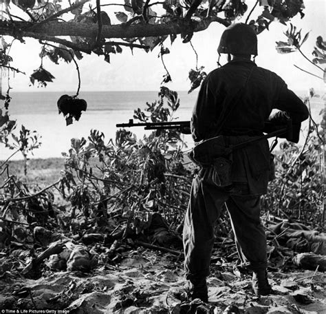 A Marine Pictured In July 1944 Looks At The Bodies Of Japanese