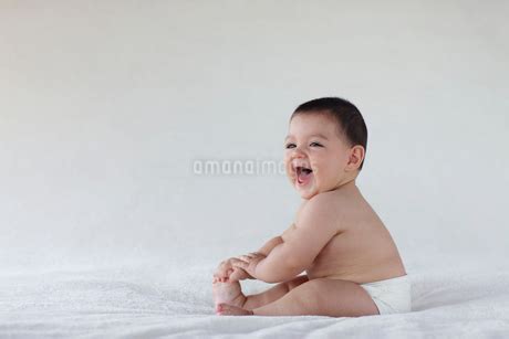 ブランケットの上に座る裸の赤ちゃんの写真素材 FYI ストックフォトのamanaimages PLUS