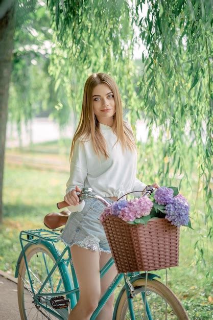 Premium Photo Beautiful Fairhaired Girl On A Bicycle With Flowers Hydrangeas