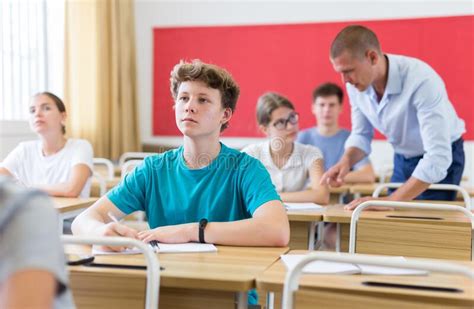 Young Students Sitting At Desks In Classroom Stock Photo Image Of