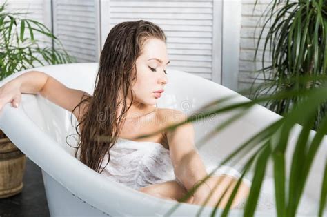 A Young Attractive Girl Relaxes In The Bathroom And Rests Against The