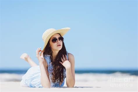 Young Girl Laying On The Beach In A Hat And Sunglasses Photograph By