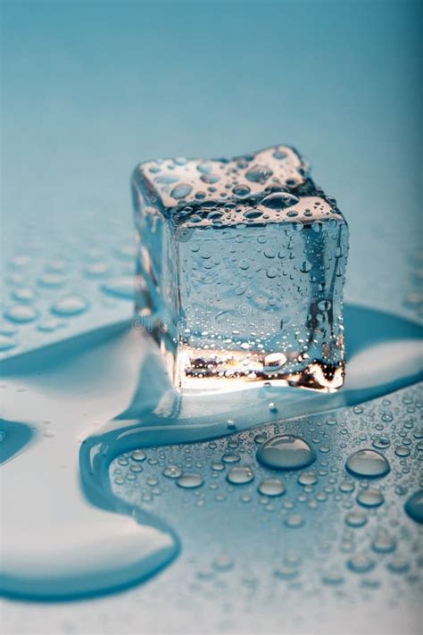 Ice Cube With Water Drops On A Blue Background The Ice Is Melting