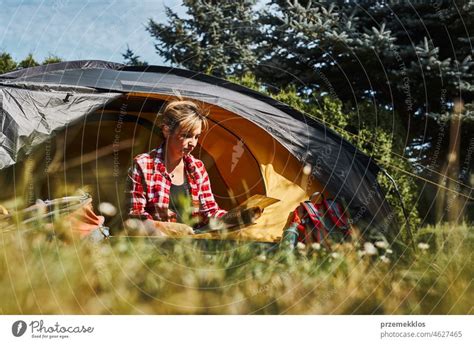 Frau plant nächste Reise während sie mit Karte im Zelt sitzt Frau