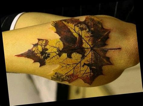 A Mans Arm With A Leaf Tattoo On It