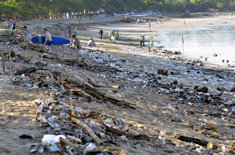 File Photo Tourists Walk Amongst Trash Washed Up On Kuta Beach By