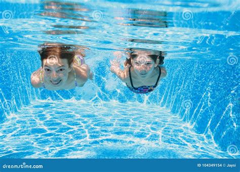 Children Swim In Pool Underwater Happy Active Girls Have Fun In Water