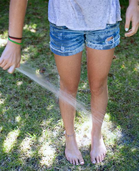 Teen Girl Spraying Herself With The Hose On A Hot Day By Stocksy