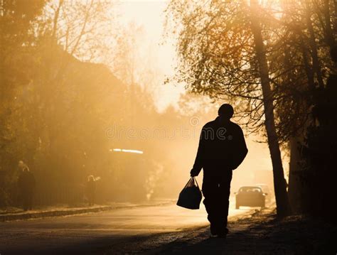 Man Walking Along The Road Backlit At Sunset Stock Photo Image Of