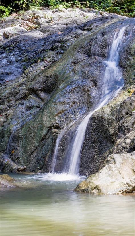 Vertical Shot Of A Waterfall Flowing Over Huge Rocks Stock Image