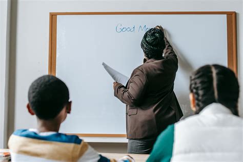 Black Teacher Writing On Whiteboard For Diverse Pupils · Free Stock Photo