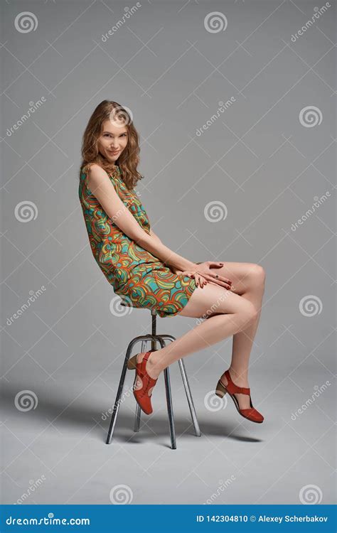 Portrait Of A Beautiful Young Girl Sitting On A Chair Stock Photo