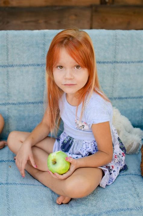 Beautiful Caucasian Girl Of Five Years Old Eats Green Apples In The