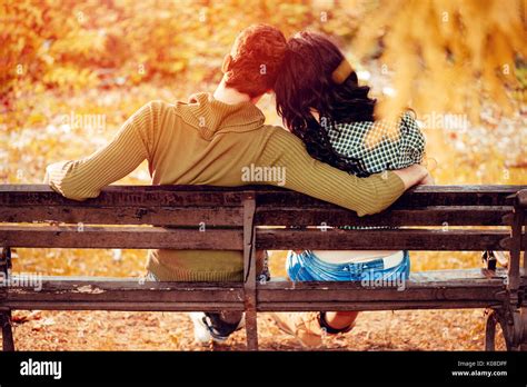 schöne paar schöne auf der bank sitzen und genießen im sonnigen park in herbstlichen farben