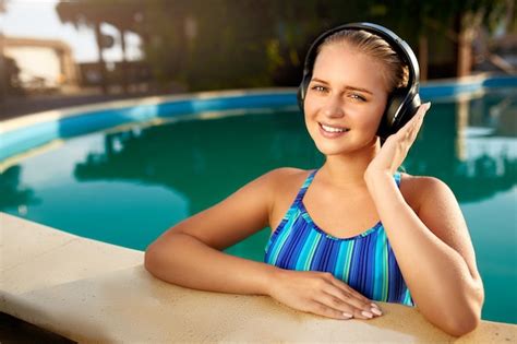 premium photo relaxed smiling woman listening to music in headphones bathing in swimming pool