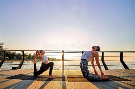 Couple Practicing Acrobatic Yoga Together On Nature Outdoors At Sea