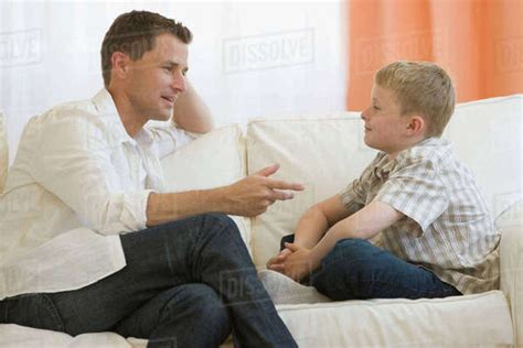 Father Talking To Son On Sofa Stock Photo Dissolve