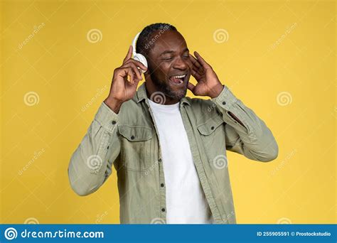 satisfied mature black man in casual with wireless headphones with closed eyes enjoy music