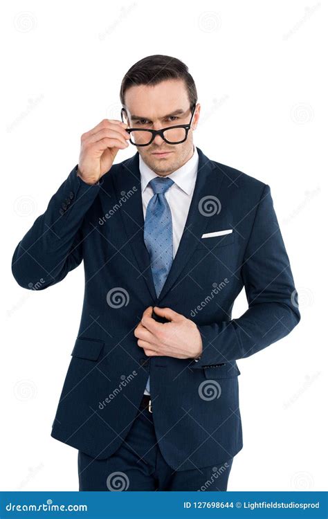 Handsome Businessman Adjusting Eyeglasses And Looking At Camera Stock