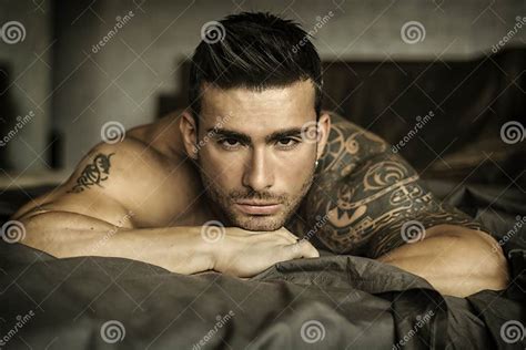 shirtless male model lying alone on his bed stock image image of attractive male 118068673