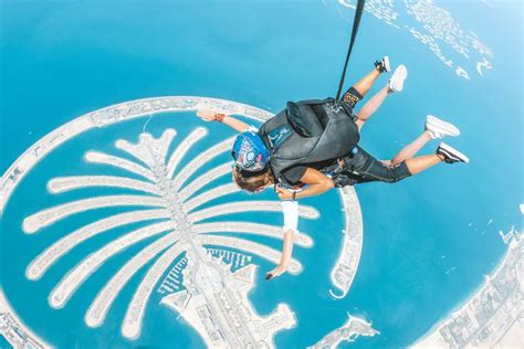 A Man Flying Through The Air While Riding A Parachute