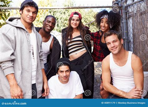 Group Of Friends In Urban Setting Standing By Fence Stock Image Image
