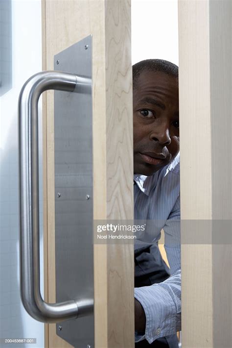 Businessman Peeking Through Door High Res Stock Photo Getty Images