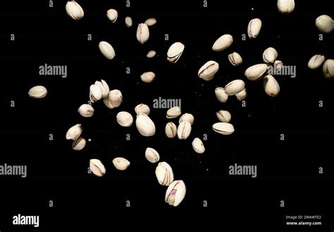 Pistachio nuts falling. In mid air on dark background. Frozen time
