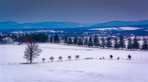 View Of Snow Covered Farm Fields And Distant Mountains From Long Stock