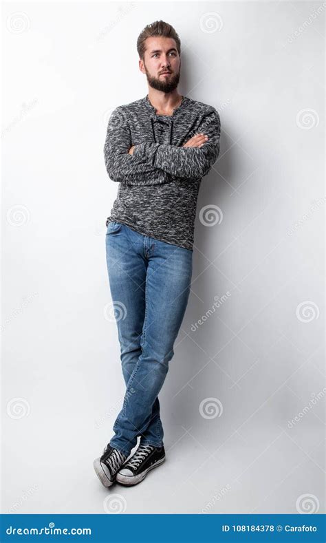 Portrait Of A Young Handsome Man Leaning Against A White Wall Stock