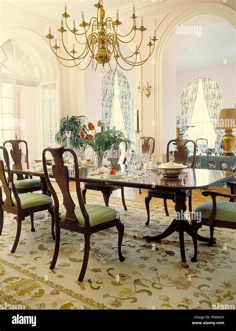 Chandelier Over Antique Mahogany Dining Table And Chairs In Opulent