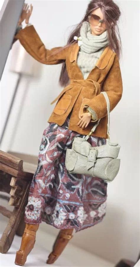 a doll is holding a purse and posing for the camera