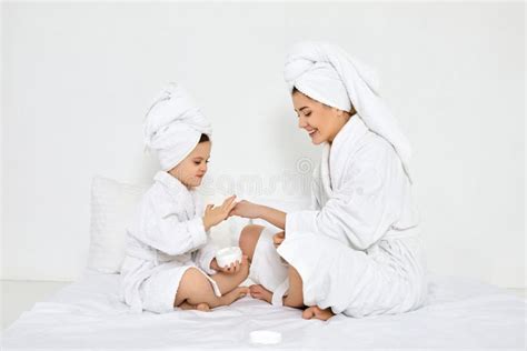 Madre E Hija En Batas Blancas Aplican Crema Foto De Archivo Imagen De
