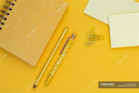 Top View Composition With Yellow Notebook And Pens Placed Near Blank