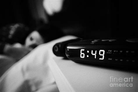 Alarm Clock Early Morning With Early Twenties Woman Lying In Bed