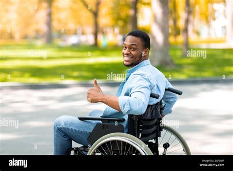 Happy Disabled Black Man In Wheelchair Spending Time At City Park In