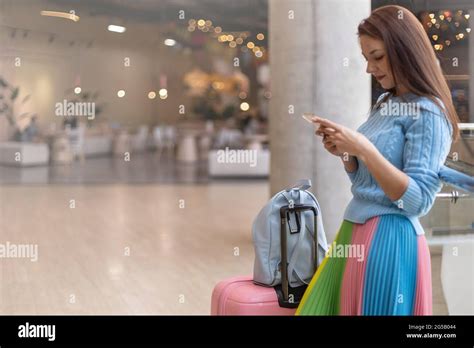 Happy Elegant Travel Woman With Baggage Standing At Duty Free Shopping