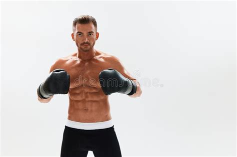 Man Athletic Bodybuilder Poses In Boxing Gloves With Nude Torso Abs In Full Length Background