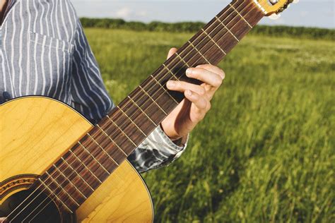 Person Playing Guitar In Grass Field · Free Stock Photo