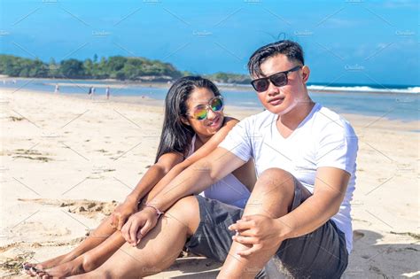 asian couple sitting on the beach of tropical bali island indonesia high quality nature