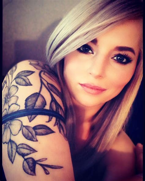 A Woman With Long Blonde Hair And Tattoos On Her Arm Is Posing For The