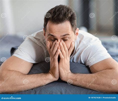 Sleepy Man Rubbing Eyes Waking Up Lying In Bed Indoor Stock Photo