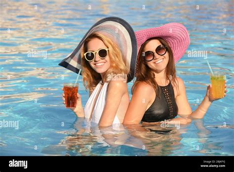 Two Beautiful Women With Cocktails Relaxing In Pool Stock Photo Alamy