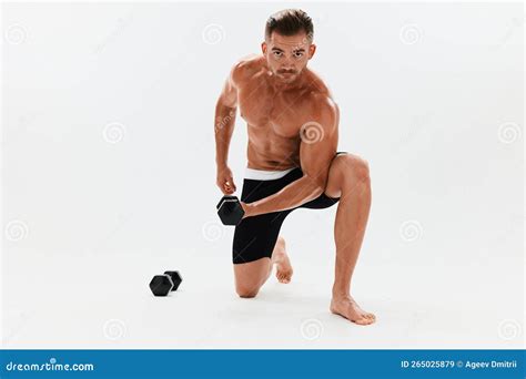 Man Athletic Body Bodybuilder Posing With Dumbbells With Naked Torso Abs Full Length In The