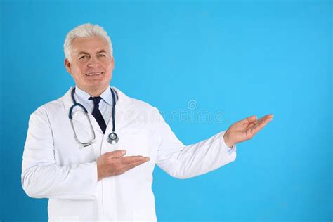 Portrait Of Senior Doctor Against Blue Background Stock Image Image