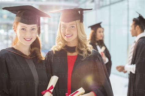 Smiling Graduates Holding Diplomas Stock Photo