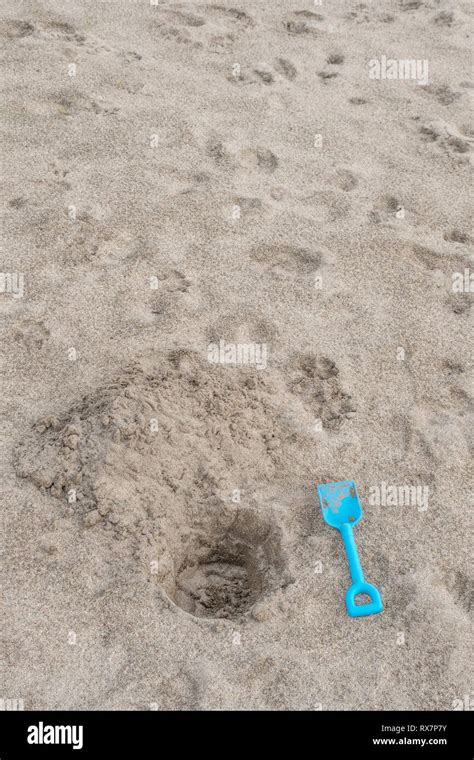 Seaside Hole Dug Into Sand With Kids Blue Spade Metaphor Dig A Hole