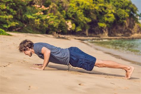 Young Male Working Out On Beach Sporty Man Doing Exercises Stock Photo