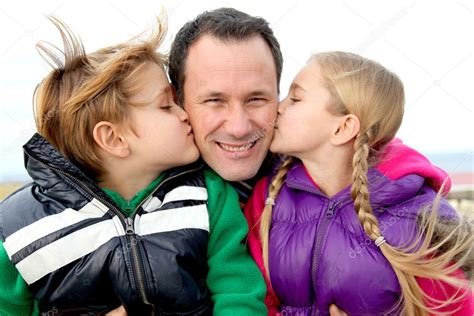Niños dándole un beso a su papá fotografía de stock Goodluz Depositphotos