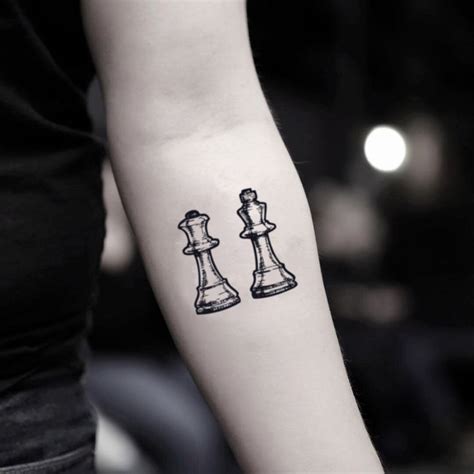 A Womans Arm With A Black And White Chess Piece Tattoo On It